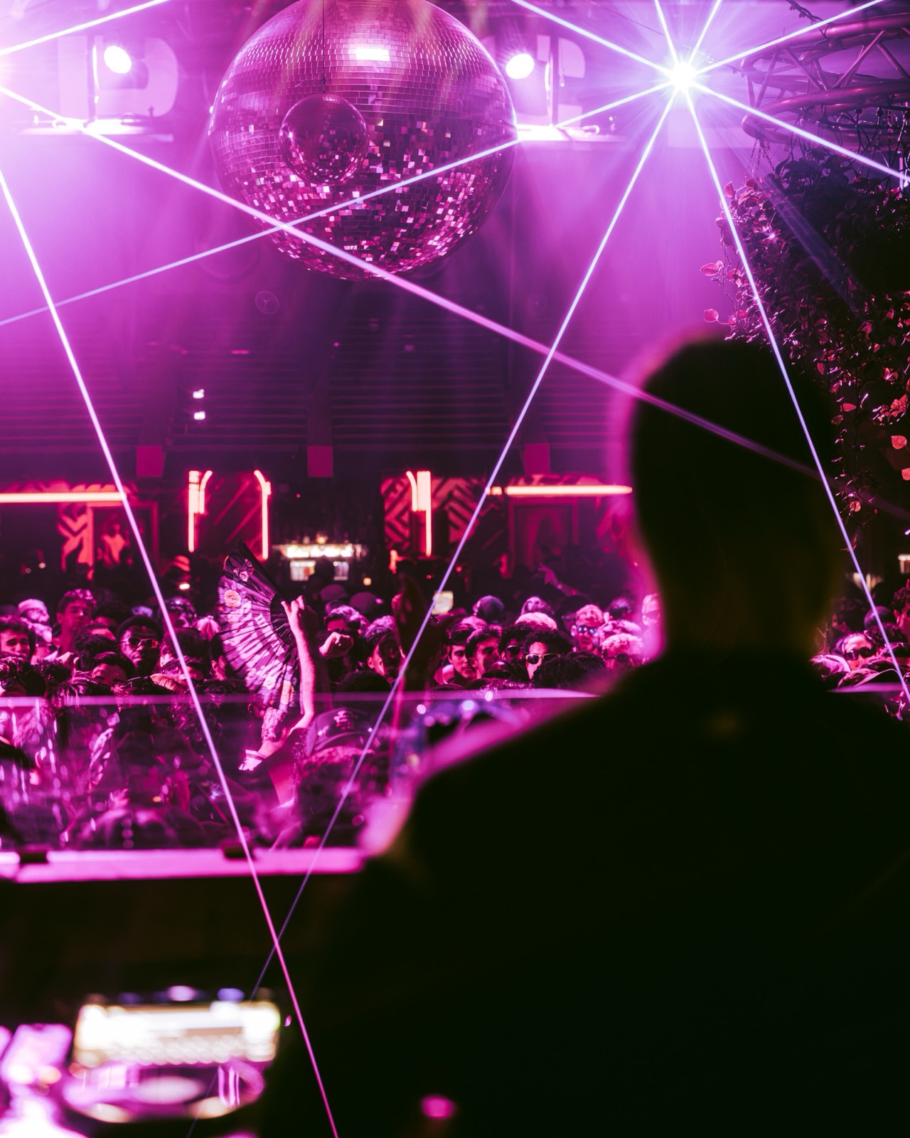 A DJ plays to a full room under the Club Space disco ball and lasers